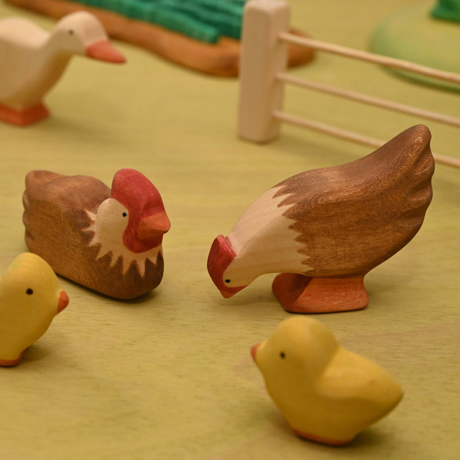Wooden pecking hen shown in profile, carved from linden wood