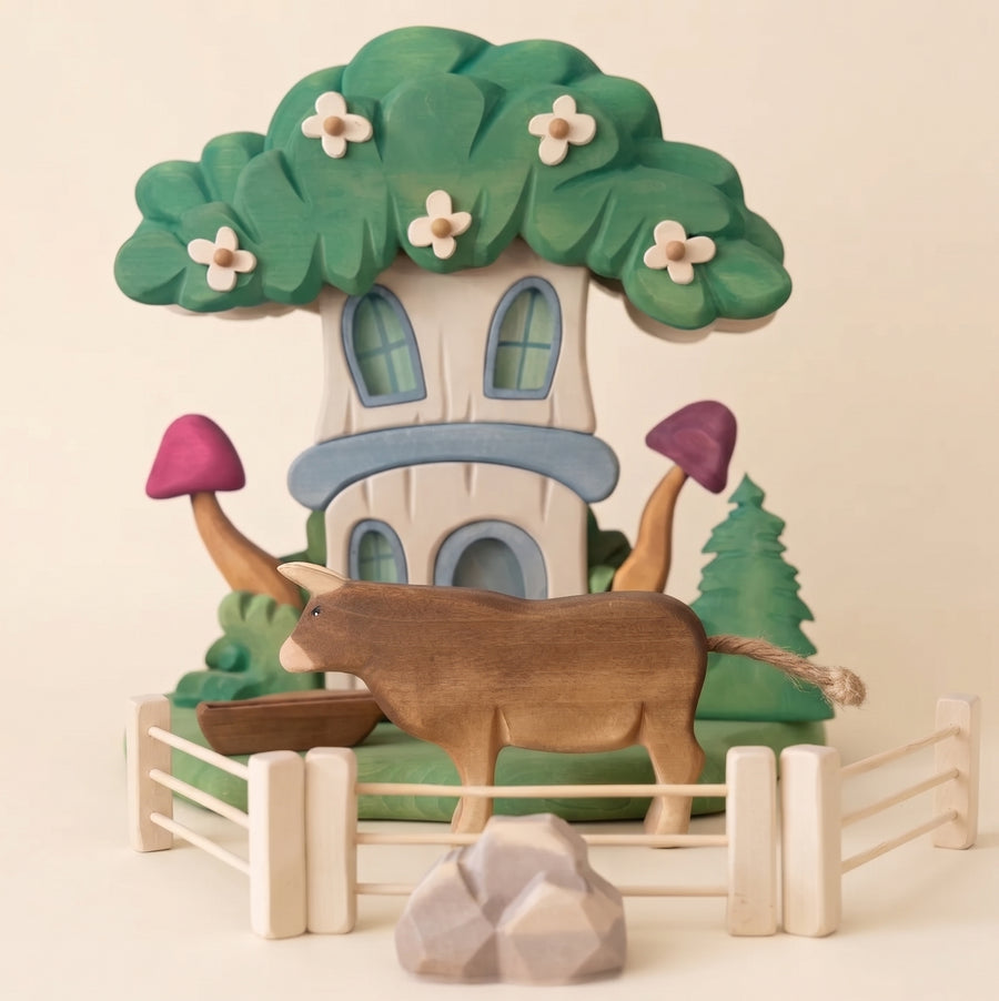 Second view of the wooden fairy house showing the carved base and garden