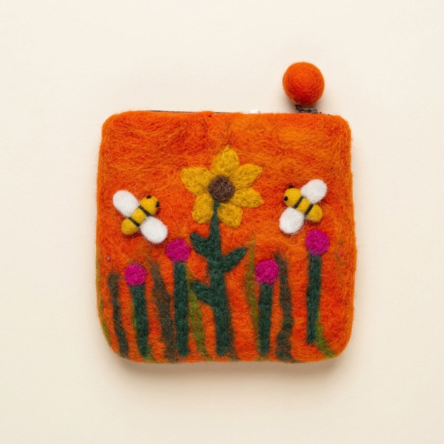 Orange hand-felted wool purse with a zip and felt-ball pull, a yellow sunflower, two felt bees and pink flowers on the front