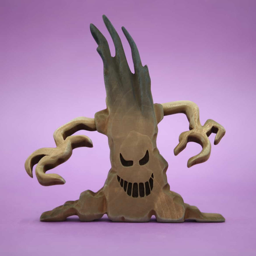 Pale wooden tree with a carved face and curling bare branches, standing on its own base