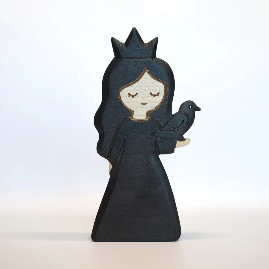 Juharka wooden black princess in a dark gown and pointed crown, holding a small bird in both hands