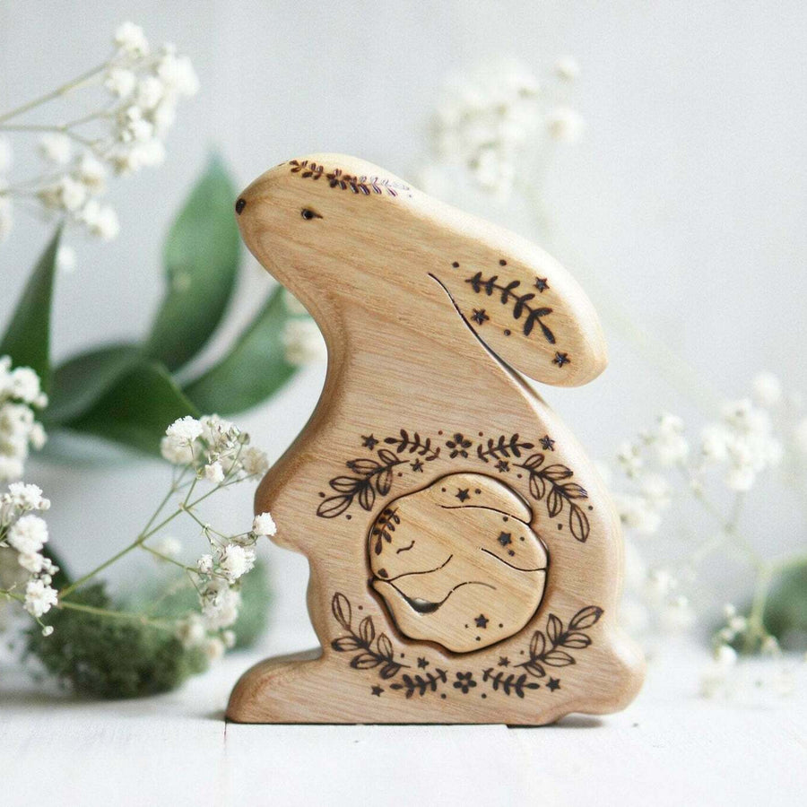 Hand-carved wooden bunny pregnancy announcement puzzle with a baby tucked inside the belly, by Tiny Fox Hole