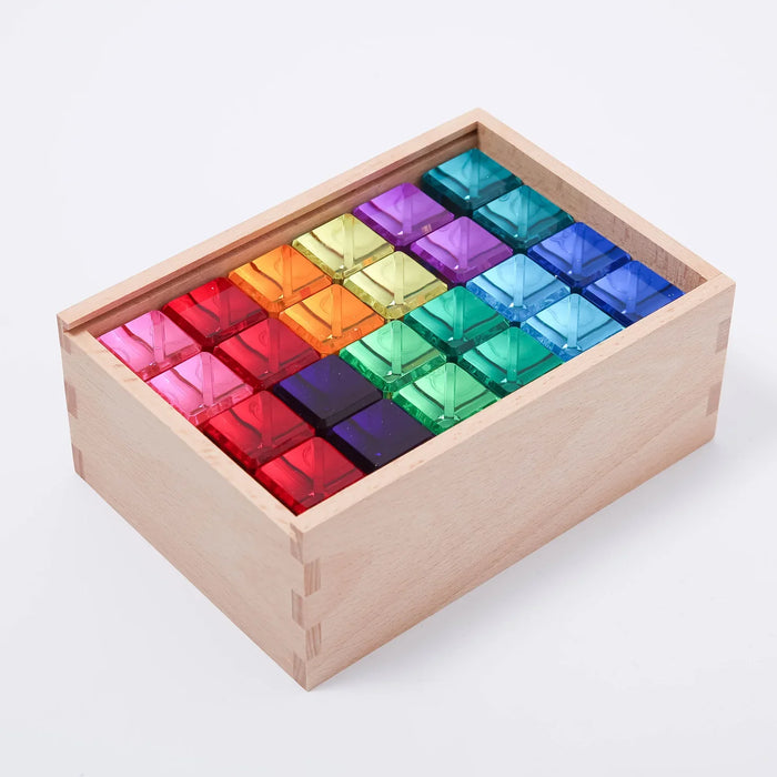 The full set of Luminous Blocks packed in a wooden box, twelve colors in two rows seen from above.