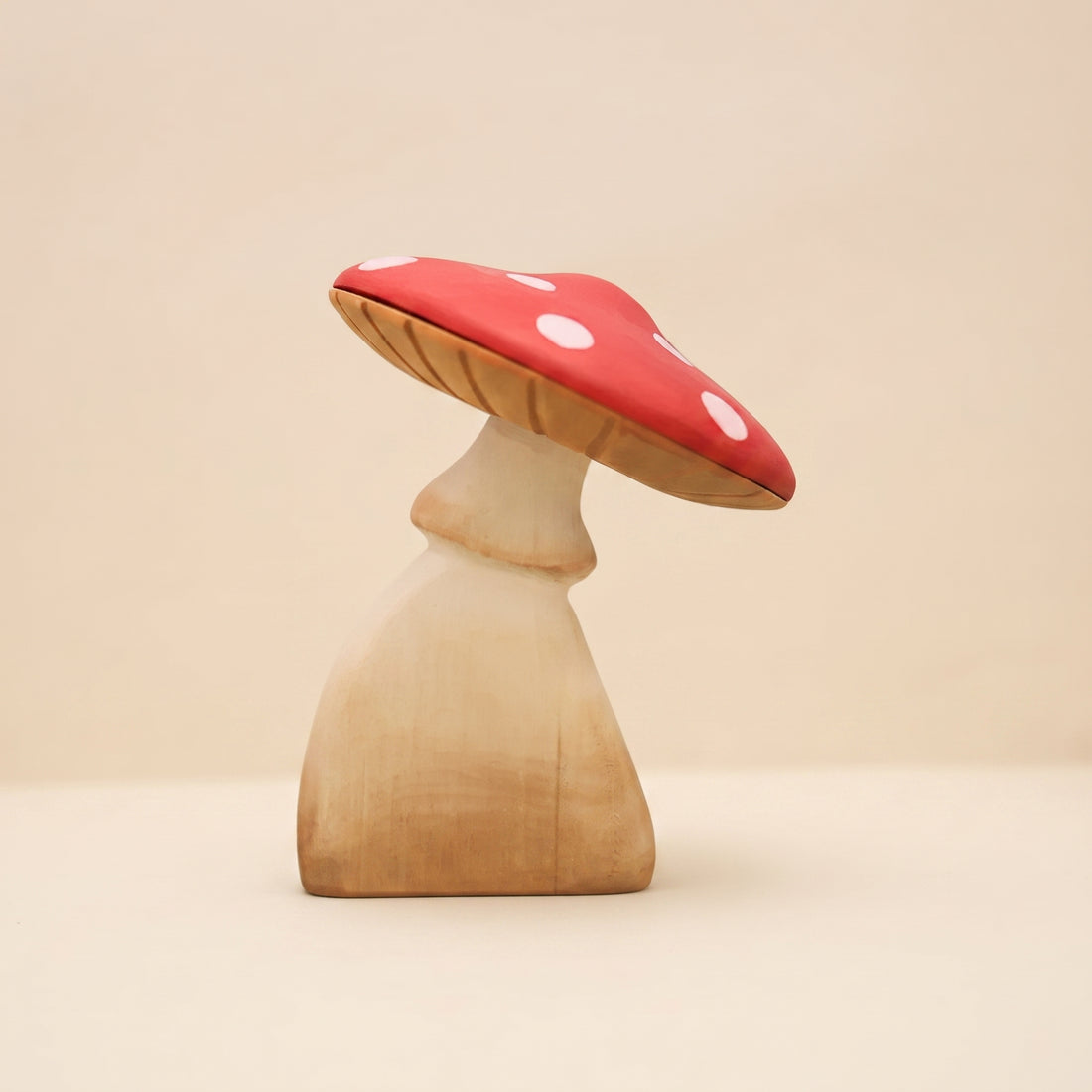 Large wooden toadstool with a red spotted cap that lifts off the pale stem