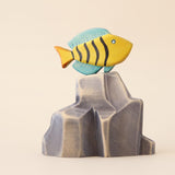 Wooden butterfly fish painted yellow with dark stripes and a blue fin · view 1