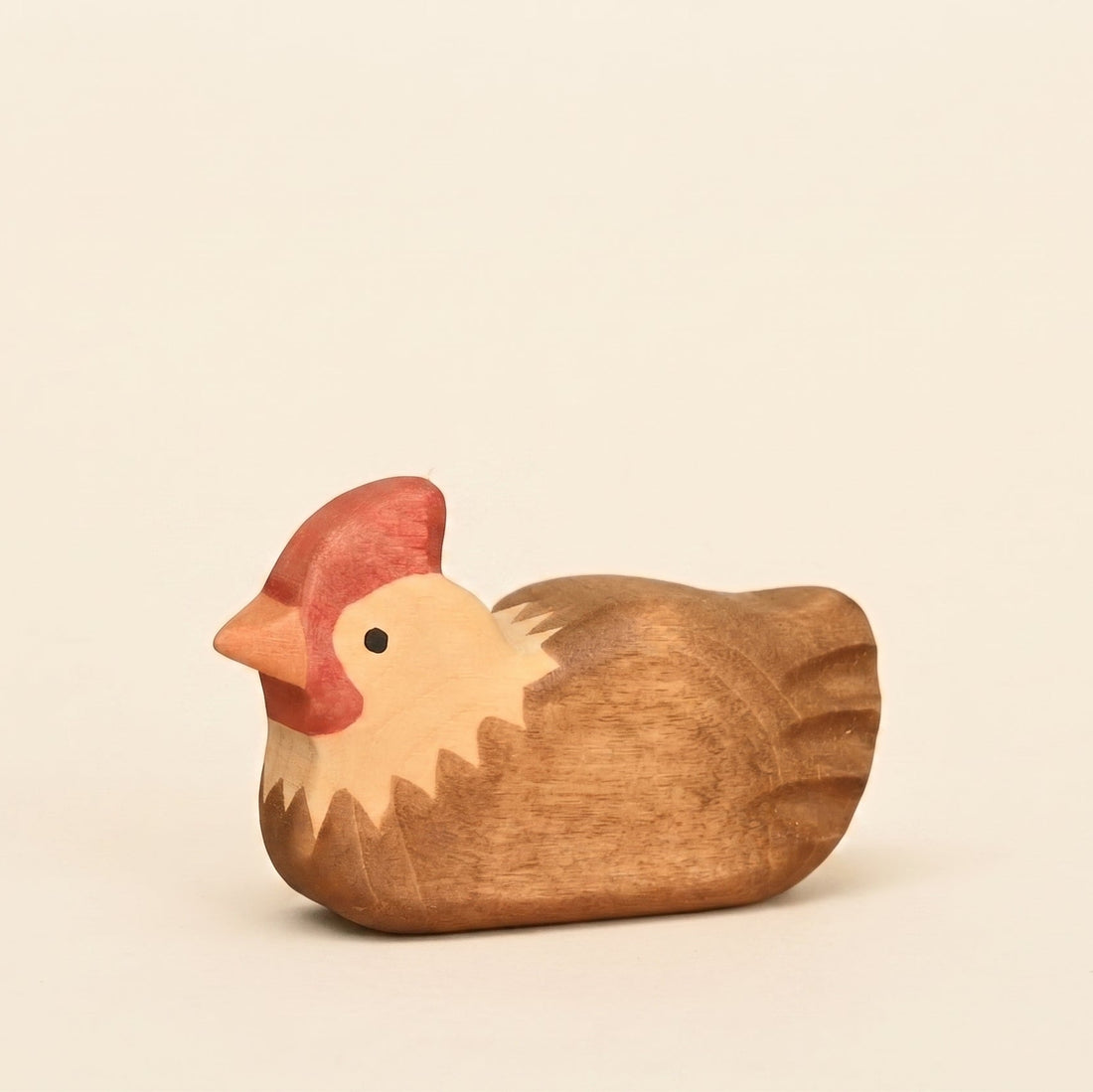 Mako Toys wooden hen sitting with feathers tucked in, painted brown and cream with a red comb