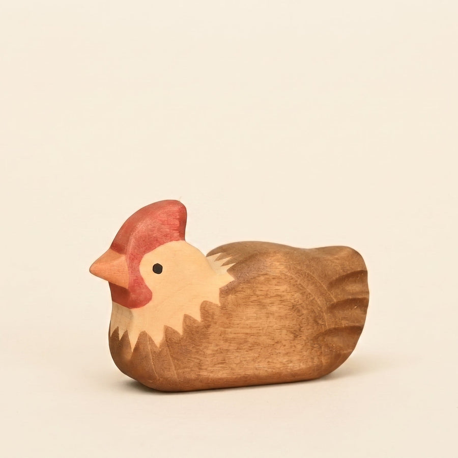 Mako Toys wooden hen sitting with feathers tucked in, painted brown and cream with a red comb