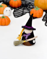 Felt witch peg doll standing beside other Halloween pieces · view 3