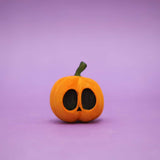 Wooden carved pumpkin with two wide oval eyes and a small triangle nose · view 1