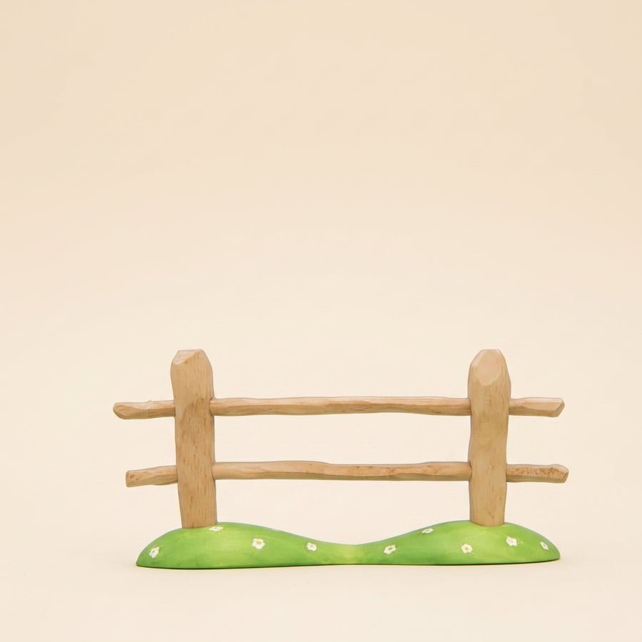 Wooden fence section with two rails on a green painted base