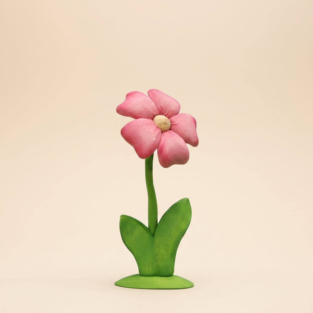 Tall wooden flower with pink layered petals and a yellow center on a green stem and base
