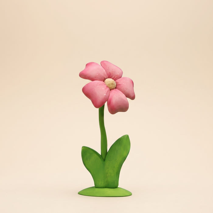 Tall wooden flower with pink layered petals and a yellow center on a green stem and base