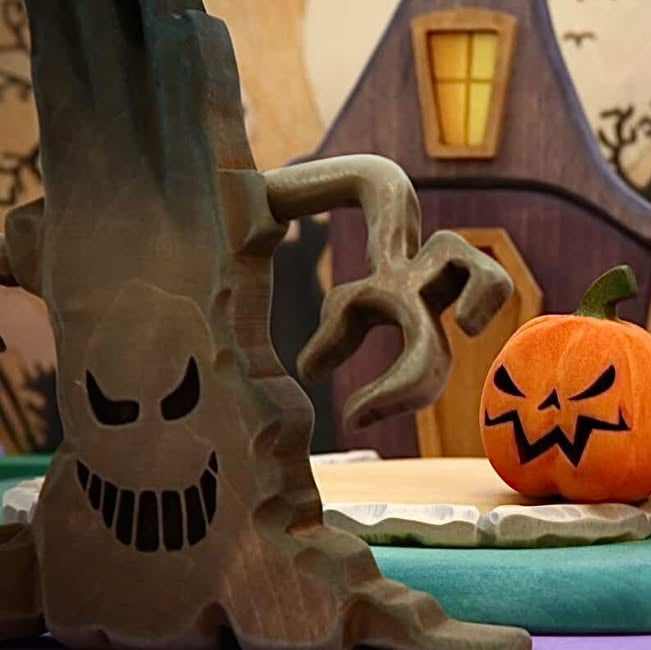 The Mako grasping tree with its carved face, beside a jack-o-lantern and the witch house