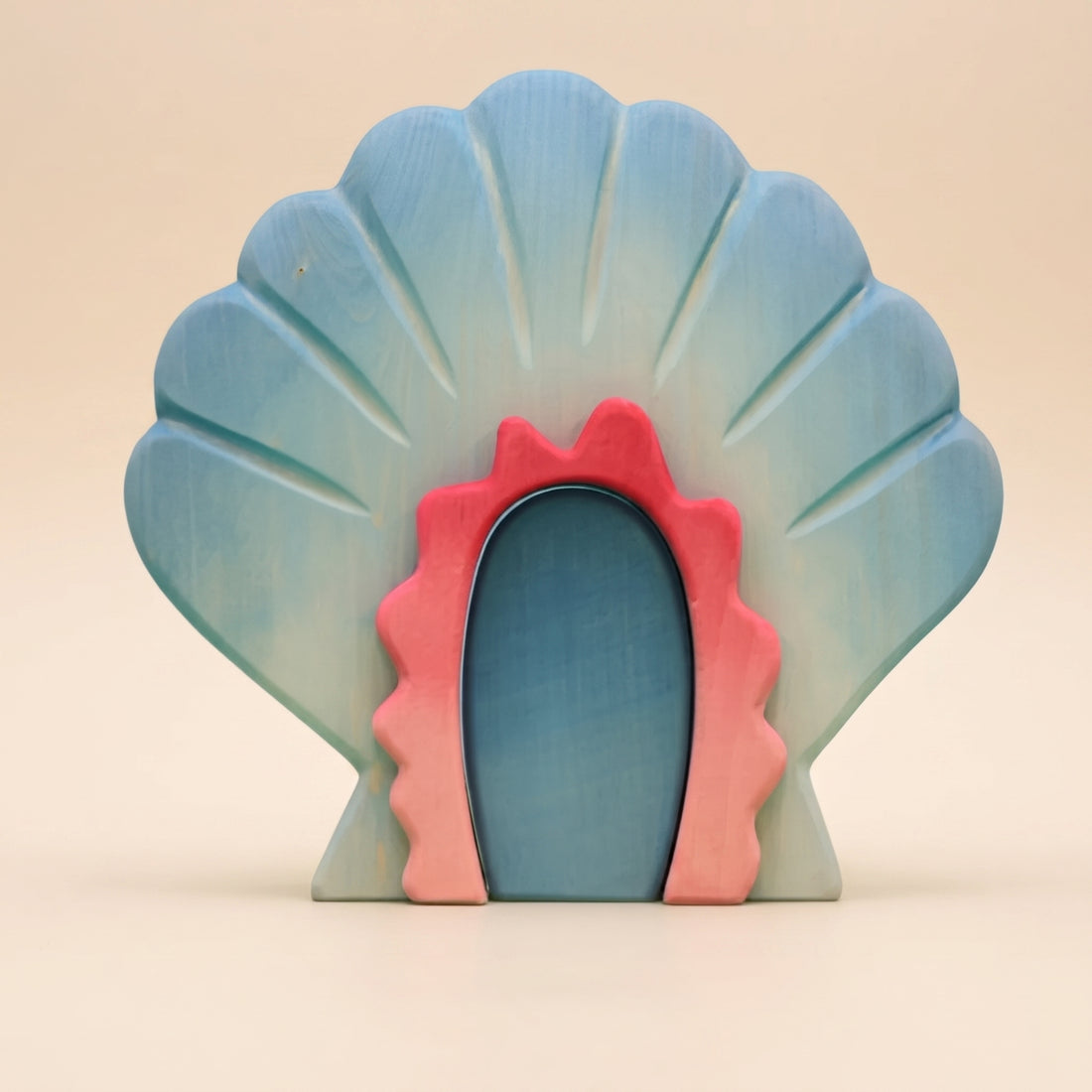 Wooden shell house, a scallop shell standing open with a coral pink doorway at its center