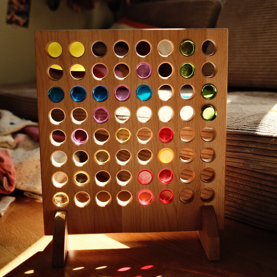 Bauspiel Four in a Row Game Board in sunlight with lucent cylinders casting colored light on the floor