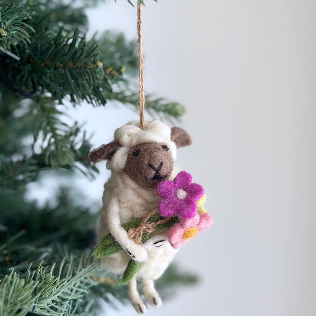 Bouquet-Bearing Sheep Ornament, a wool felt ornament by Ganapati Crafts Co., needle-felted and hand-stitched in Nepal
