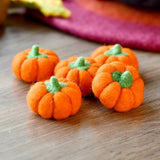 Bright orange felt pumpkins arranged together to show the size of the set · view 3