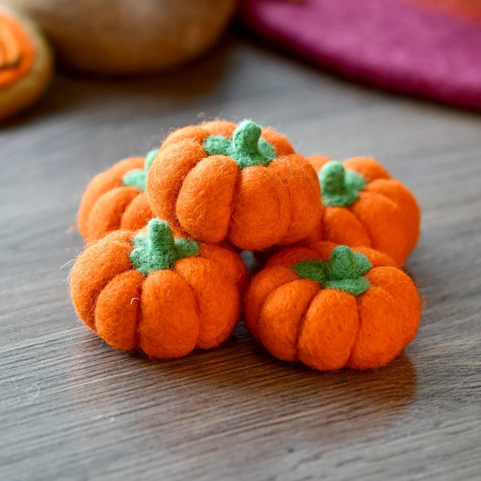 Five small felt pumpkins in bright orange, each with a stitched stem