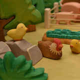 Wooden sitting hen shown from the side, with carved tail feathers · view 2