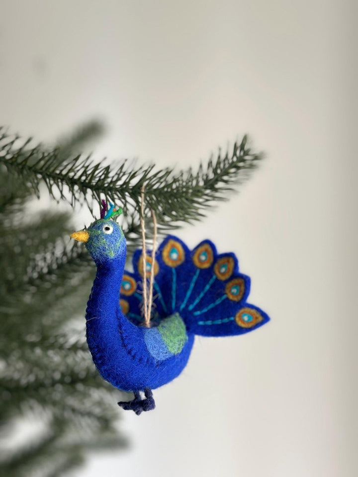 Handmade wool felt peacock ornament with a fanned blue and green tail hanging from a loop