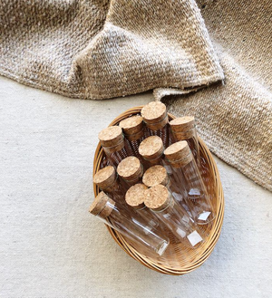 Cork-topped glass specimen bottles gathered in a basket, ready for a class to fill