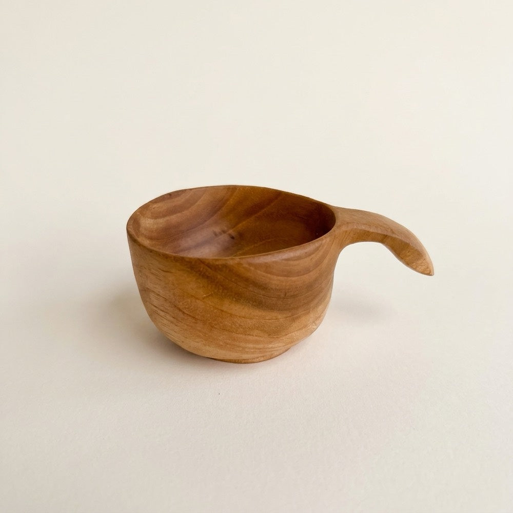 Small teak pouring cup with a curved handle