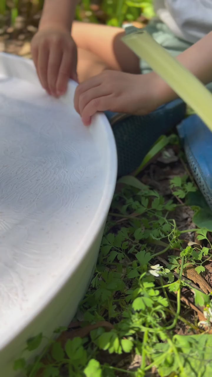 The Busy Bee Tray in use: a child moving loose parts between the inserts.