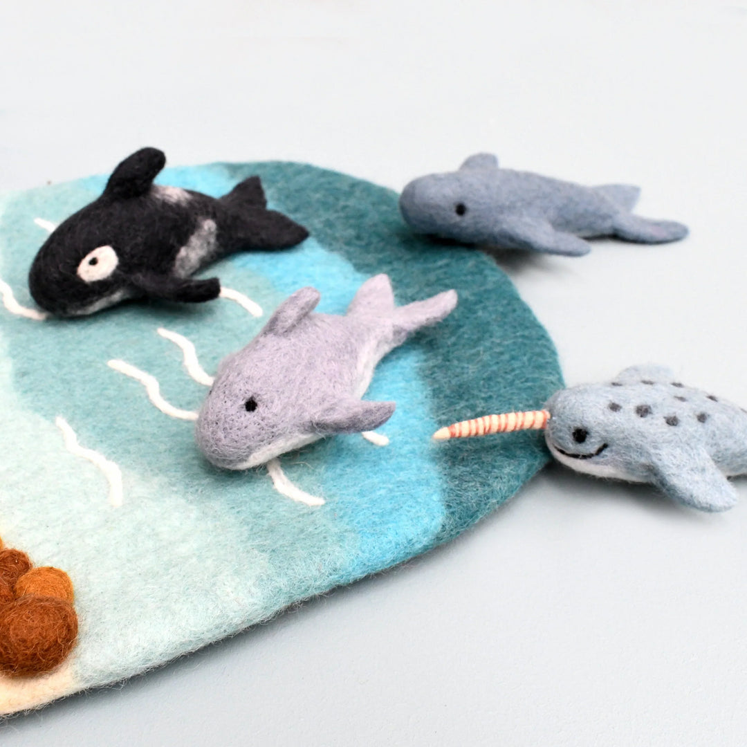 The felt orca, dolphin, whale and narwhal swimming across a felt ocean play mat