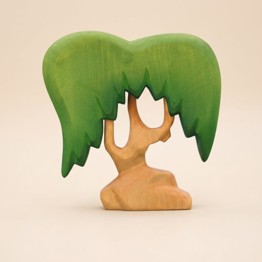 Wooden willow tree with a green canopy hanging down on both sides of a pale forked trunk