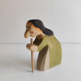 Hand-carved maple witch shown in profile, holding a removable wooden walking stick · view 1